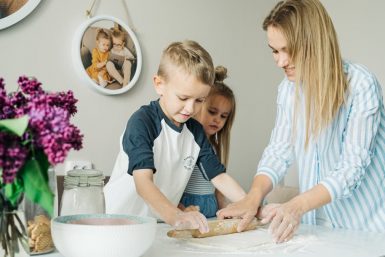 Mother and children enjoying a fun and messy baking session together at home.