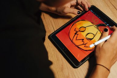 Creating a Halloween pumpkin illustration on a tablet with a stylus.